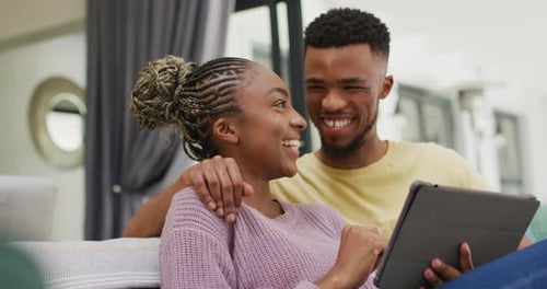 Happy Couple Using Tablet at Home
