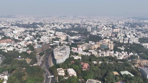 Aerial daytime view of Hyderabad showcasing dense urban development, modern buildings, green