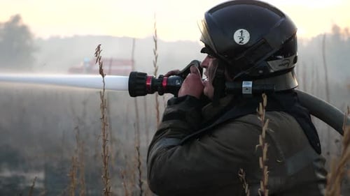Firefighter Extinguishing Wildfire in Rural Field