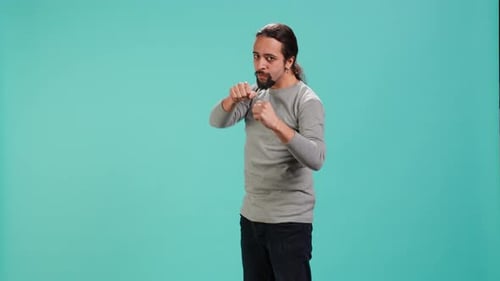 Adult Man Boxing in Front of Blue Background
