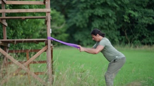Man Does Resistance Band Exercise Outdoors