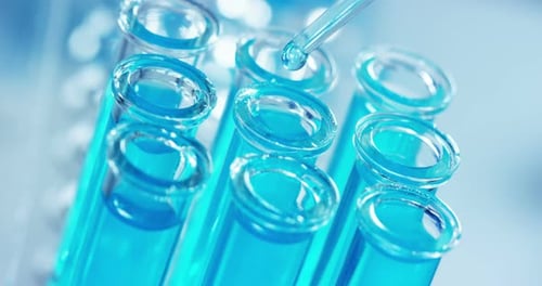 Lab Test Tubes with Blue Liquid Being Filled