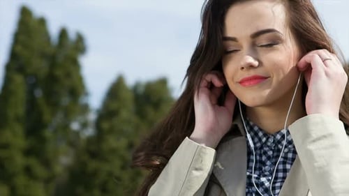 Beautiful Young Women in Headphones Listening to the Music
