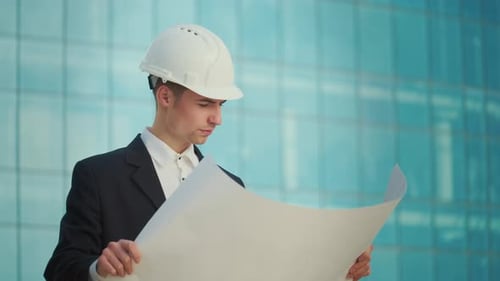 Architect Reviews Building Plans in Urban Setting