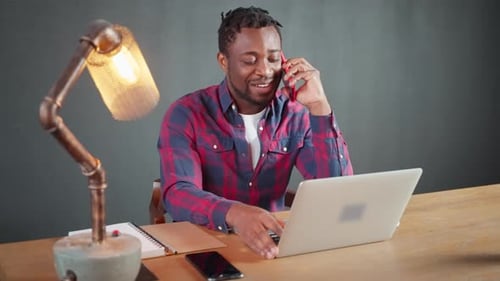 African American Businessman is Talking By Phone in Home Office SMM Professional Working Remotely