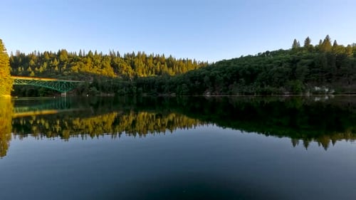 Bäume und Brücke spiegeln sich im Meer