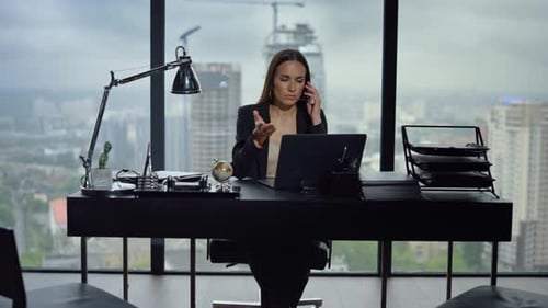 Serious Businesswoman Talking on Smartphone in Modern Office. Female Entrepreneur Having Conversatio