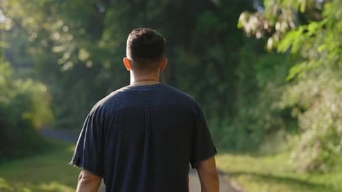 Multiracial Male Tourist is Seen From the Back Stroll Down the Park Exploring the Area on Foot Young