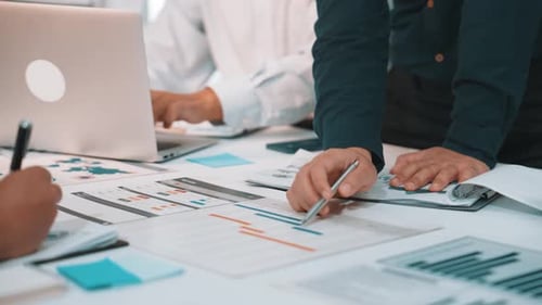 Profissionais de negócios colaborando na análise de projetos usando gráficos, relatórios e dados para estratégia