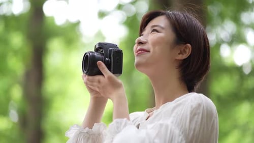 Woman Taking Pictures in Verdant Green Park