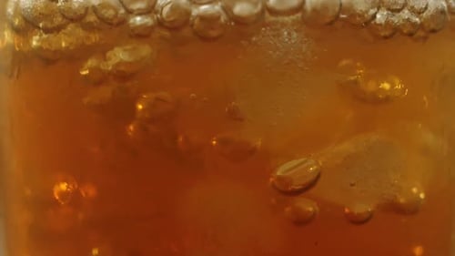 Refreshing Amber Beverage with Ice Cubes Close Up