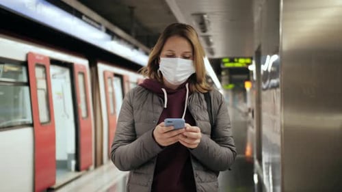 Mulher usando máscara médica cirúrgica protetora, proteção facial enquanto espera no metrô ou no trem