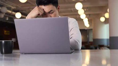 Young Man Working on Laptop in an Office