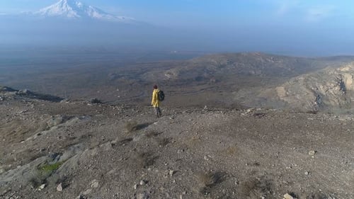 Trendy backpacker journeying to mountain peak overlooking autumnal national park