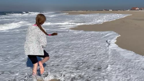 Teenager Run Along the Coast of the Pacific Ocean and Enjoy the Sun and Waves The Girl is Playing