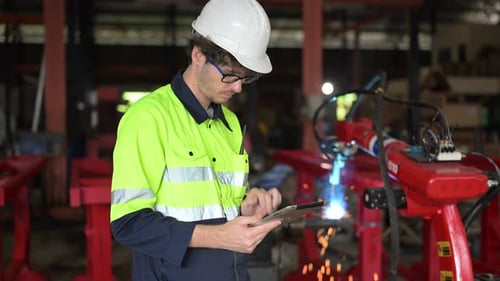 Mechanical Maintenance Engineer Using Tablet Working at Factory