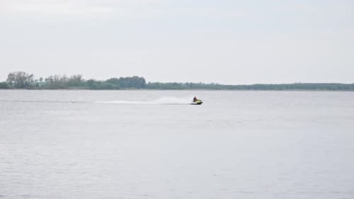 A water scooter sailing Through the Lake, Creating a Splash of White Water in its Wake - Wide slow m
