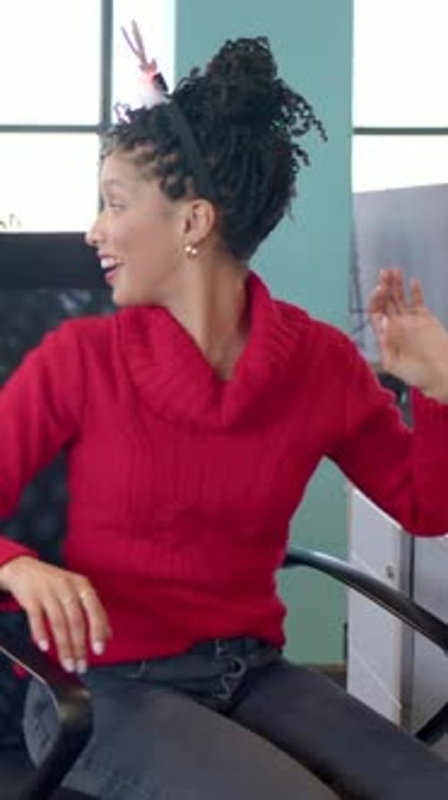 Vídeo vertical: percebendo que o presente foi estendido, mulher de suéter vermelho estendendo a mão até a mesa do escritório, faixa iluminada