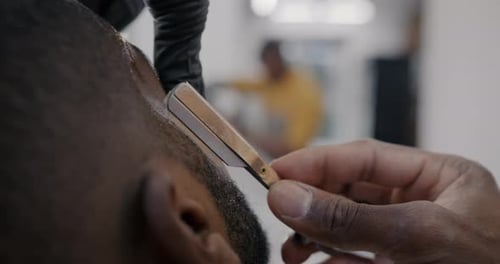 Barber Shaving Man's Hairline with a Straight Razor