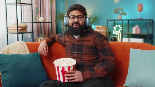 Man Enjoys Movie with Popcorn on Couch