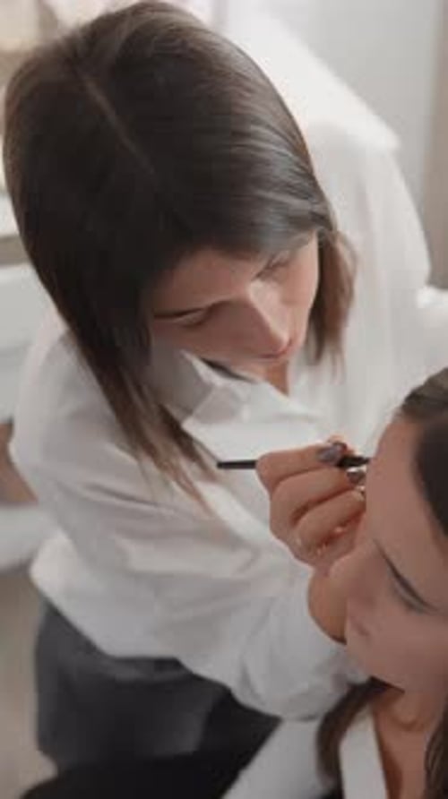 Professional Makeup Artist Applying Flawless Makeup to a Client in a Modern Studio Beauty Expert