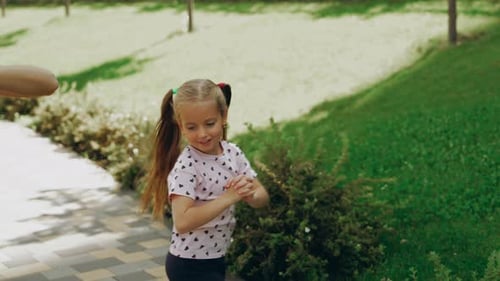 Young Girl Excitedly Plays in the Park on a Sunny Day