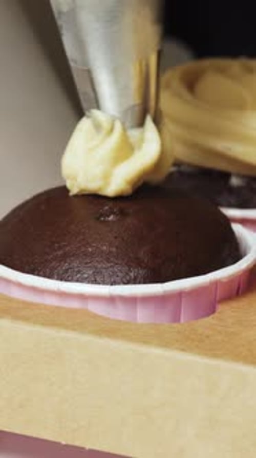 Chocolate cupcakes decorated with peanut paste cream Vertical video.