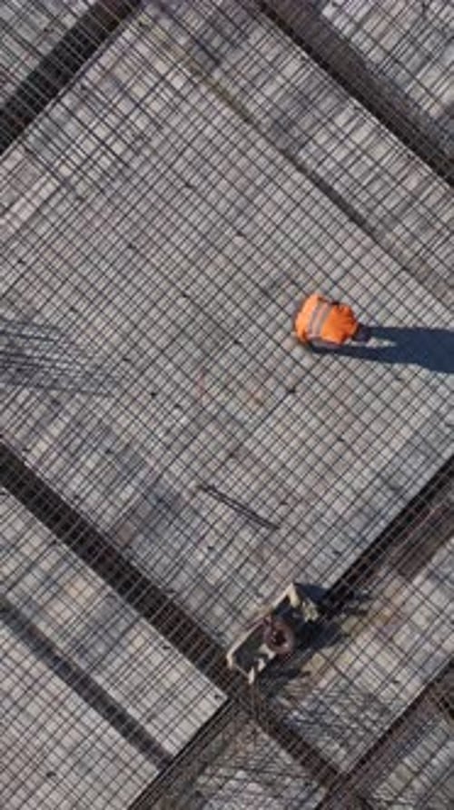Vídeo vertical en perspectiva aérea de una obra de construcción con andamios y trabajadores preparando nuevos