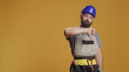 Portrait of Construction Worker Giving Thumbs Down in Studio