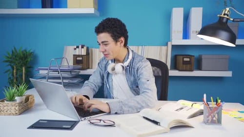 Excited Teen Working at Desk Celebrates Success