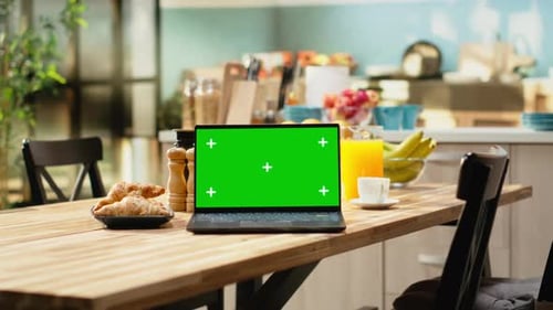 Chroma Key Mockup on Laptop Screen in Rustic Kitchen Interior with Wooden Table