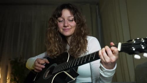 Woman Plays Acoustic Guitar and Sings