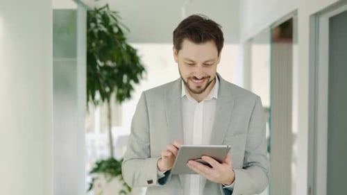 Businessman Going in the Office Using Digital Tablet Thinking About New Project