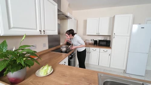Young Woman Cooking Food in Bright Kitchen