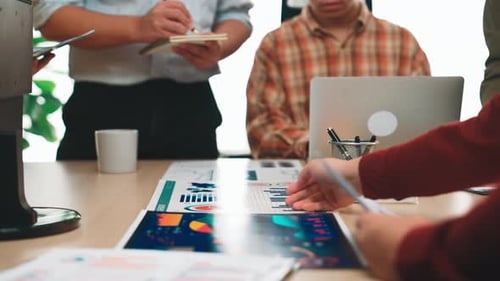 Team Analyzing Data and Graphs at Meeting Table