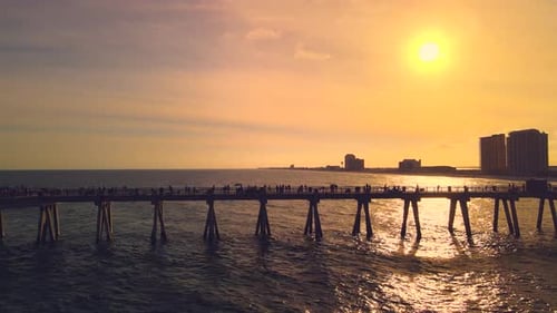 A dramatic orbit around the longest pier in Florida as it stretches from the sand into the ocean wit