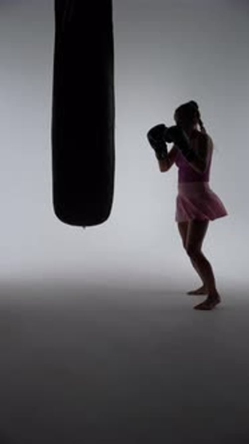 Kickboxing Woman Fighter Trains His Punches Beats a Punching Bag Training in the Dark Boxing Gym