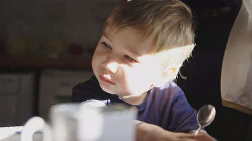 Adorable Blond Child Sitting with Spoon