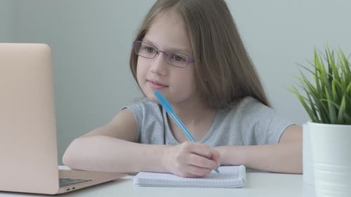 Girl Studies Using Laptop and Notebook