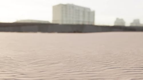 Early Morning Empty Beach Against City Buildings