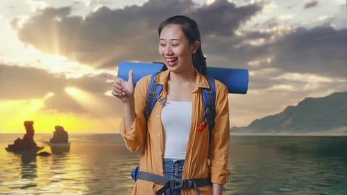Asian Female Hiker Smiling And Pointing To Side on Beach