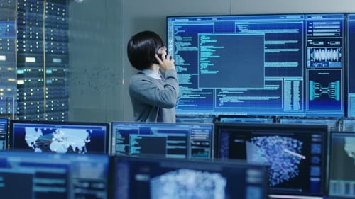 Na sala de controle do sistema, o administrador de TI fala ao telefone. Ele está em uma instalação de alta tecnologia que W