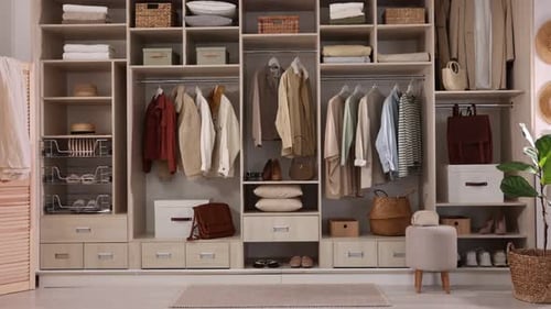 Armoire avec différents vêtements élégants et articles de maison à l'intérieur, zoom avant