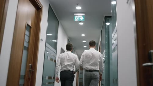 Businessmen walking discussing corporate information data in modern office