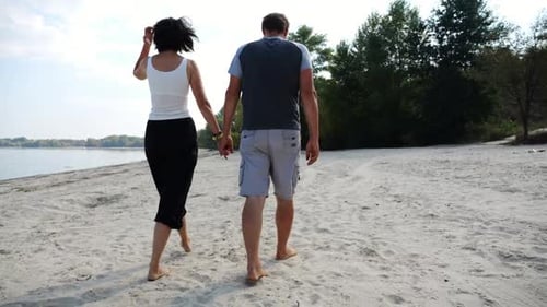 Couple Holding Hands of Each Other and Walking at Coast Happy Pair Going Along Seashore at Sunny Day