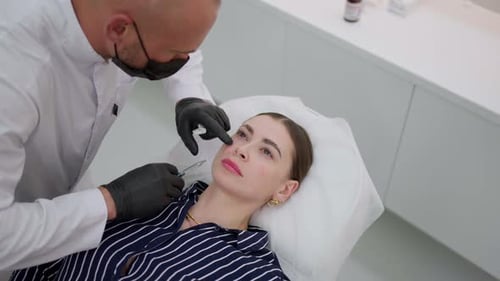 Procedimiento médico de tratamiento de inyección cosmética El médico en bata blanca realiza una inyección en la cara de