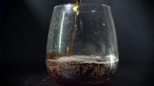 Bubbling Brown Liquid Being Poured Into a Glass