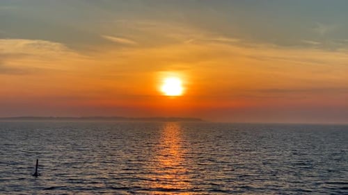 sunset over calm misty ocean