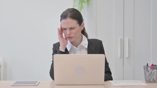Woman Suffering from Headache in Office Workplace