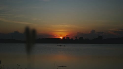 Sunset Over a Calm Lake with Boat